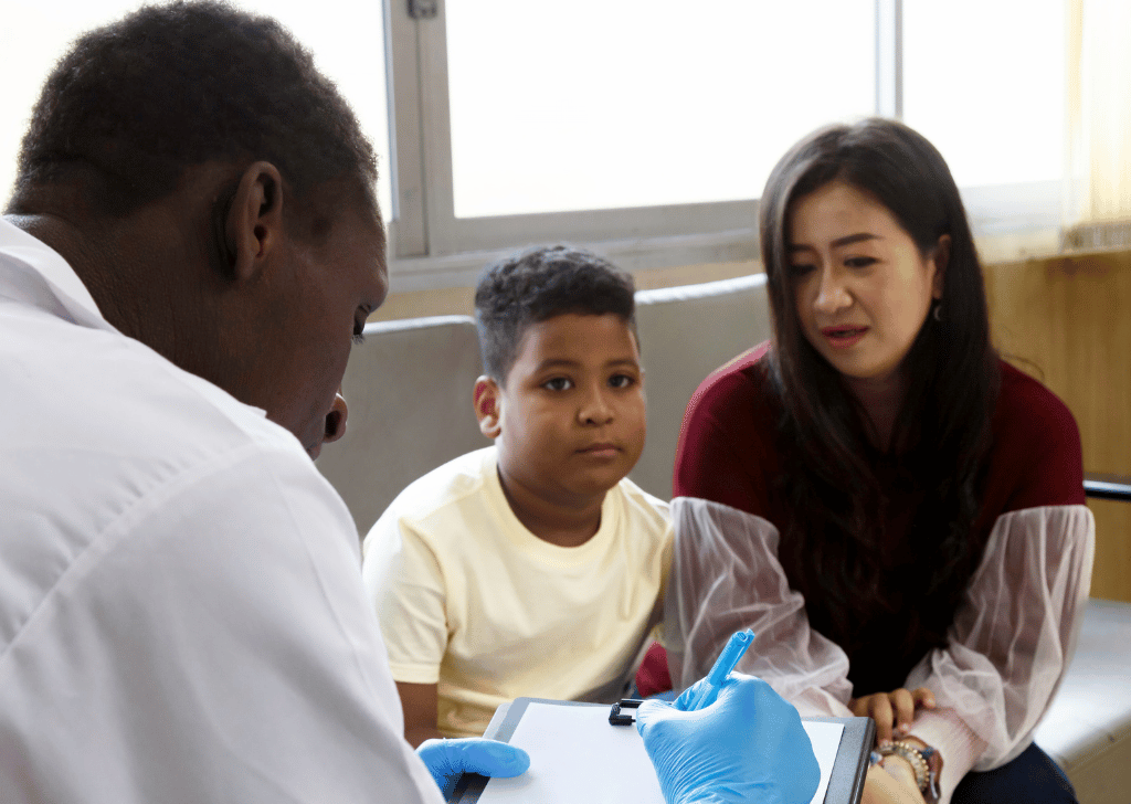 mother and her boy talk to african american pediatrician doctor 