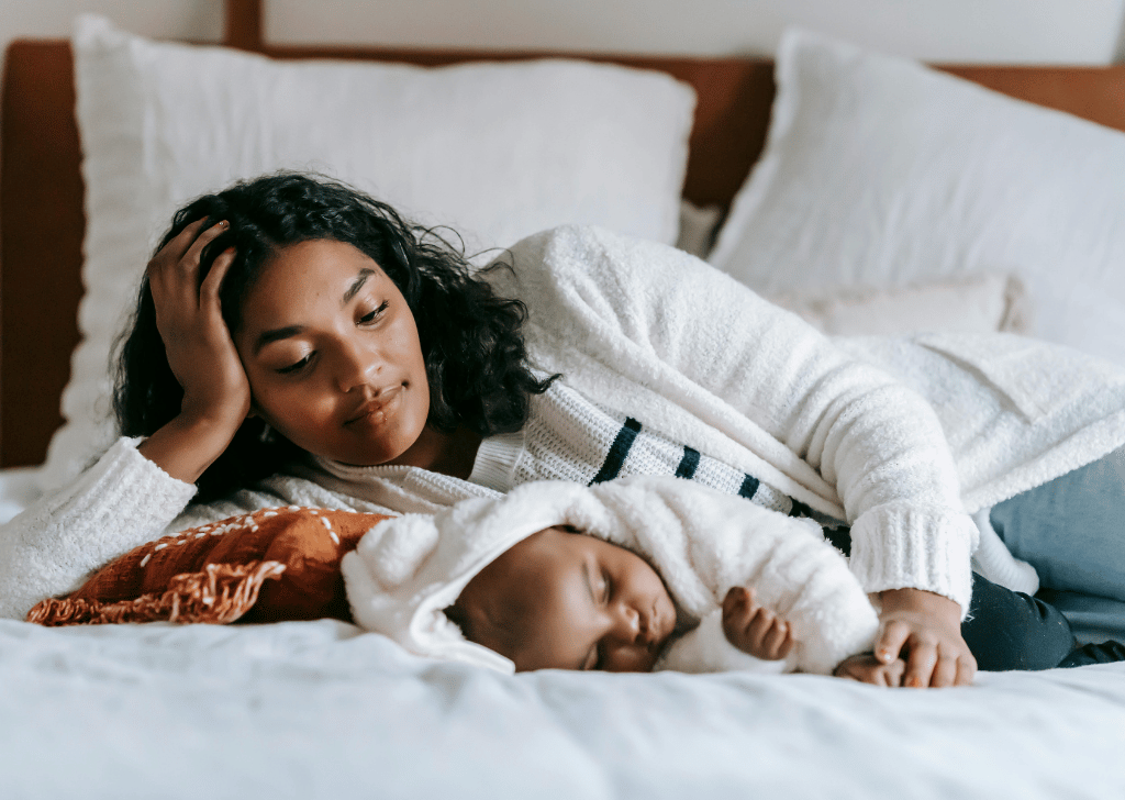 Young Black mother laying with her newborn baby.