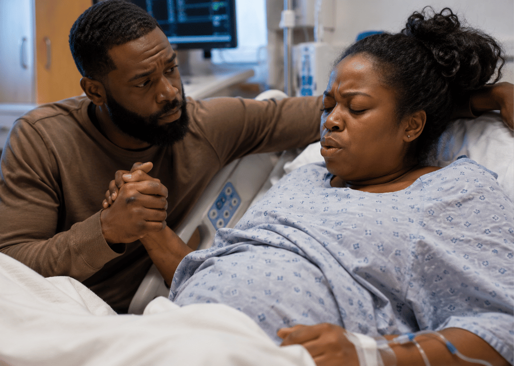 Black male doula partner with birthing Black woman.